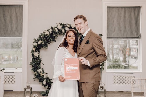 Bride and groom holding Crisis certificate