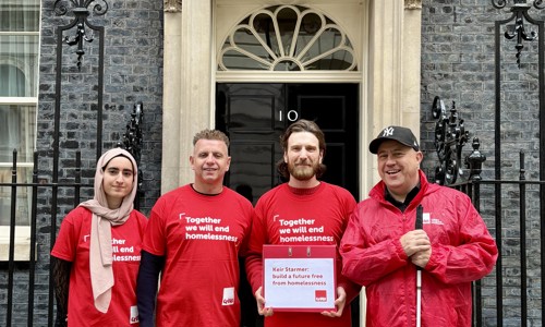Crisis campaigners stand outside 10 Downing Street with a box of campaign signatures.