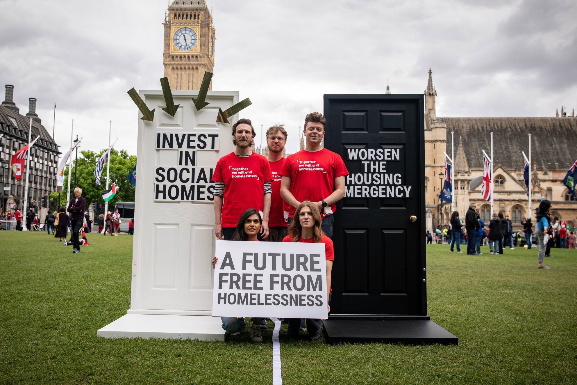 Five people in Crisis t-shirts standing in Parliament Square, holding a sign that says 'A future free from homelessness.'