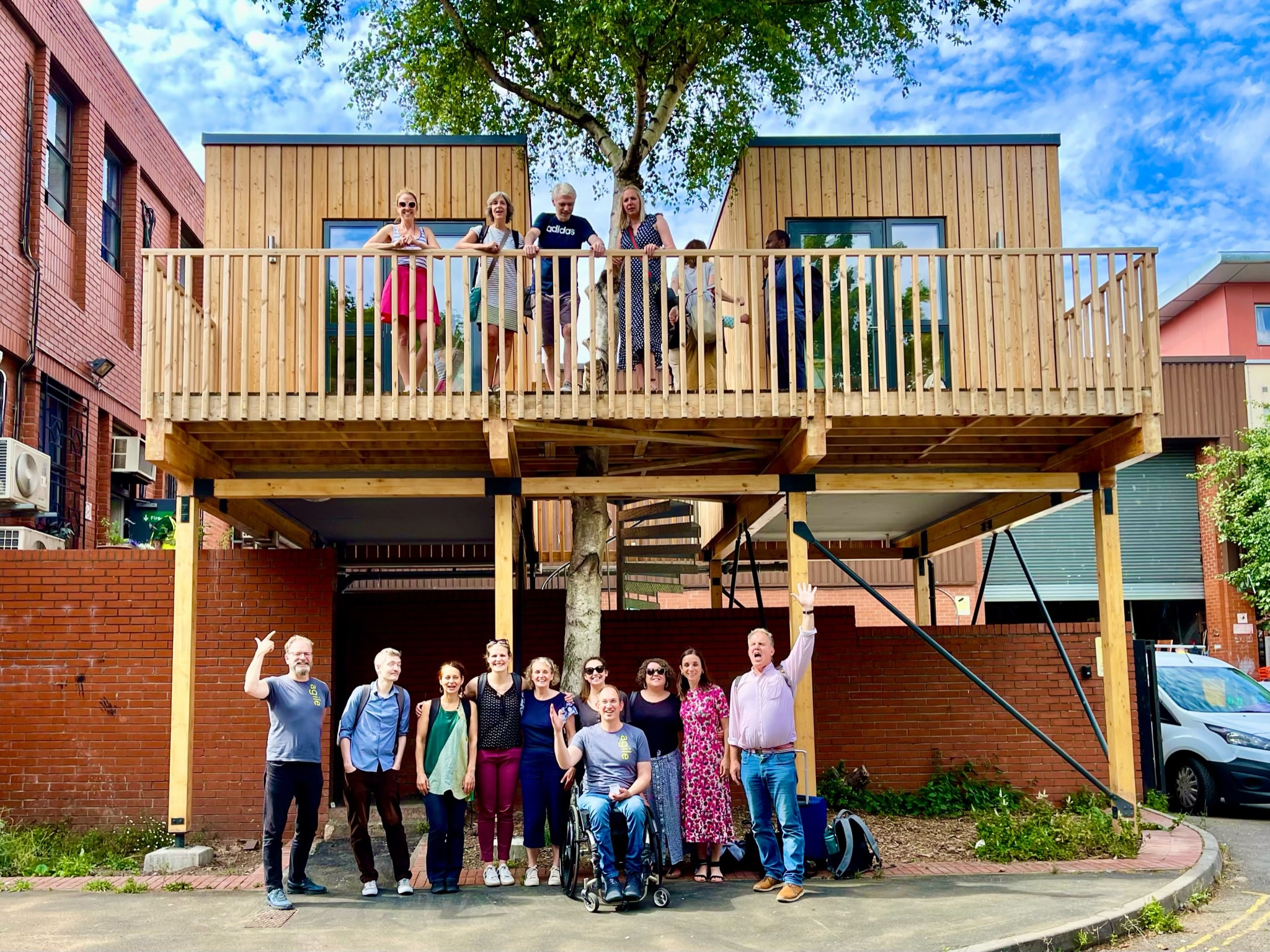 People from Agile Homes standing in front of a low-carbon, affordable home they built. 