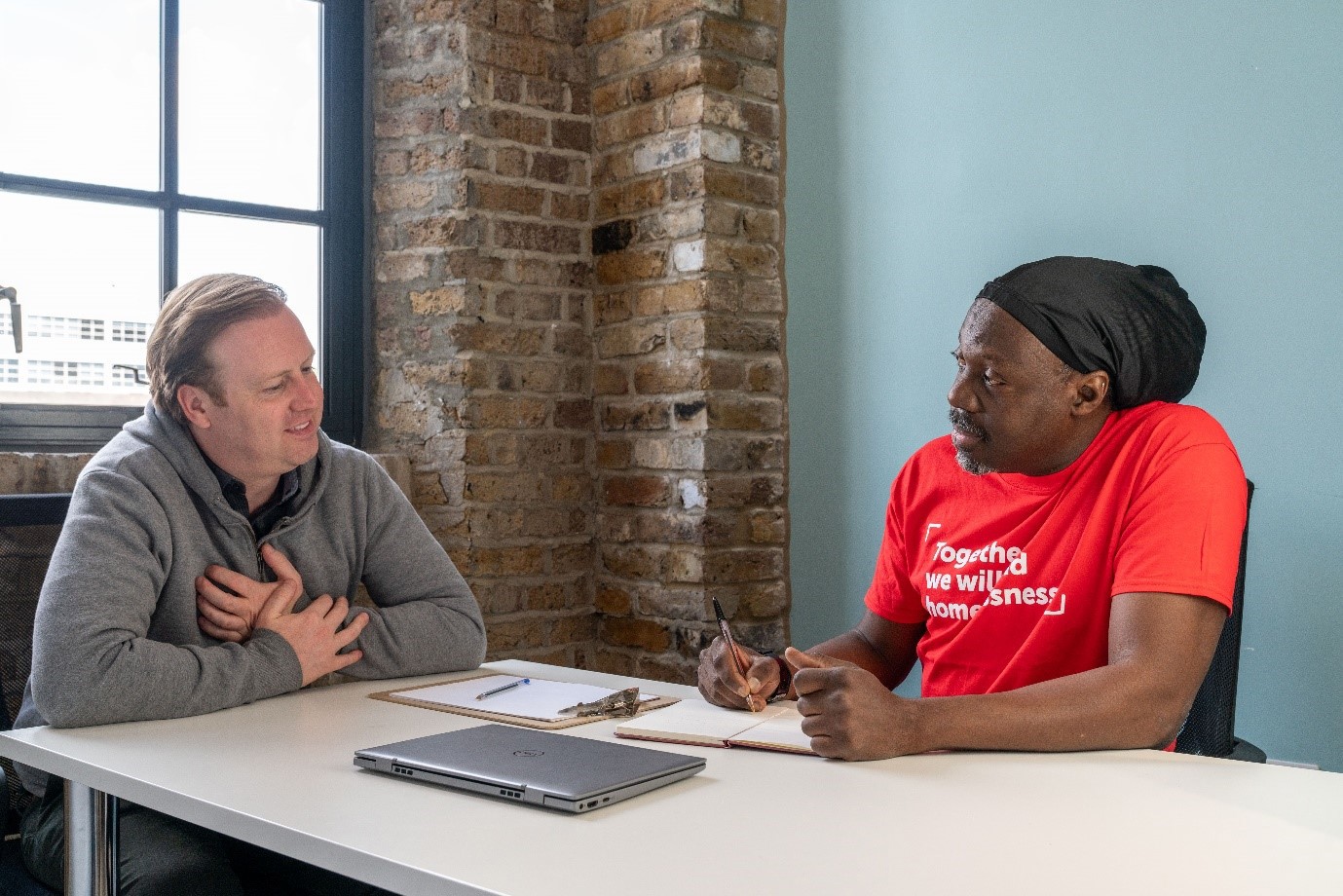 Crisis volunteer sits at a desk talking with a member. 