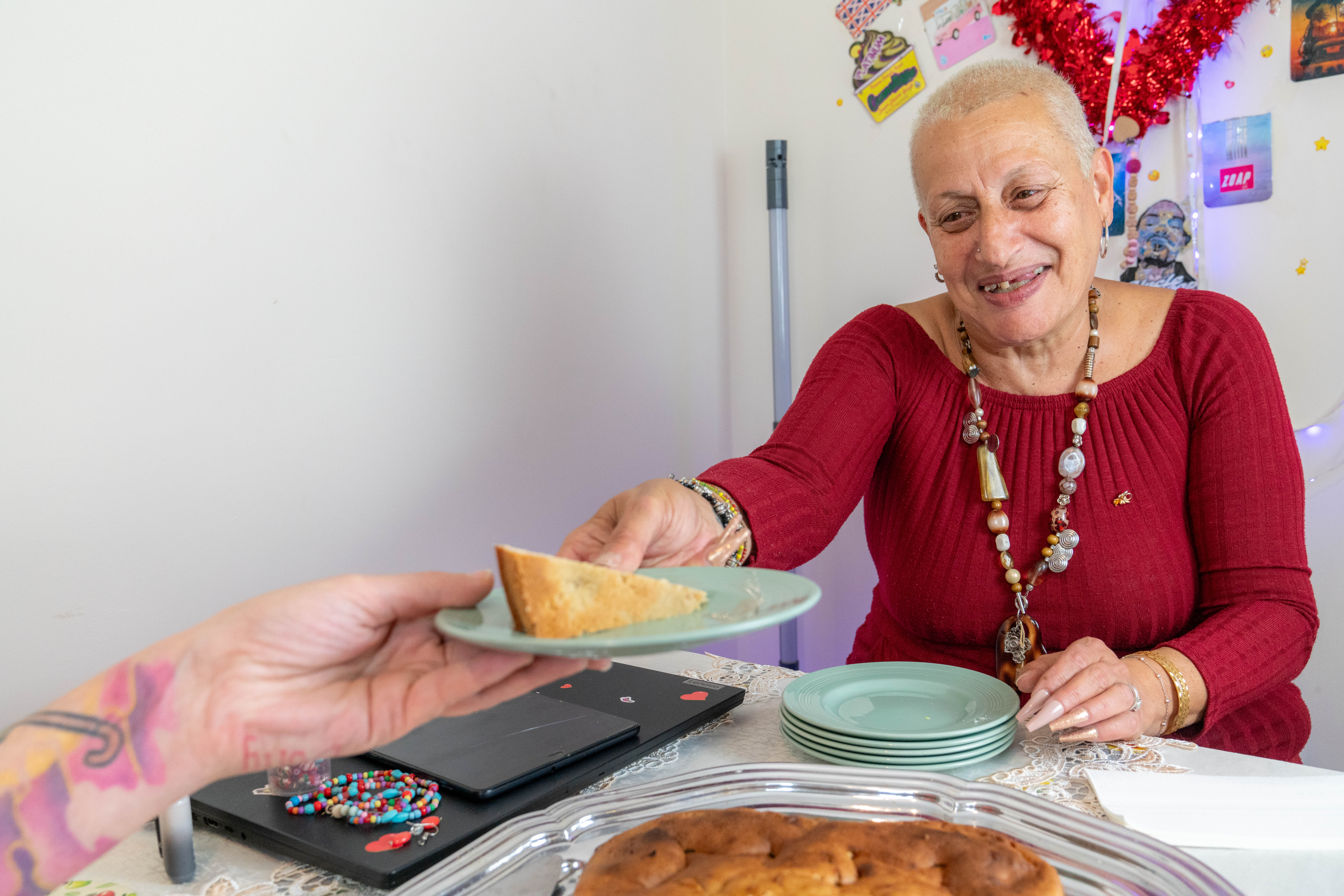 Eva passes a piece of cake to someone out of shot